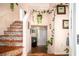 Inviting foyer featuring stone-accented stairs, hardwood floors, and decorative greenery at 7865 Lake Ter, Douglasville, GA 30134