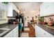 Galley kitchen featuring white cabinets, granite countertops, and a view of the dining area at 7865 Lake Ter, Douglasville, GA 30134