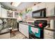 Well-lit kitchen with white cabinets, black appliances, and charming decor with green plants at 7865 Lake Ter, Douglasville, GA 30134