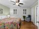 Bright bedroom with hardwood floors, white brick wall, and colorful patterned bedspread at 1026 Saint Charles Ne Ave # 10, Atlanta, GA 30306