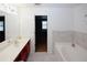 A bright bathroom features white tile floors, a soaking tub, and double sinks with a large mirror at 1290 Adcox Sq, Stone Mountain, GA 30088