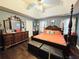 This primary bedroom boasts a decorative four-poster bed, dark wood flooring, and a ceiling fan at 33 Bo Xing, Temple, GA 30179