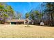Single-story home with a well-maintained lawn and storage shed, surrounded by tall trees at 33 Bo Xing, Temple, GA 30179