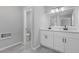 Bathroom with double vanity and modern fixtures, doorway to toilet room, and gray wood-look floors at 851 Ashley Ln, Stone Mountain, GA 30087