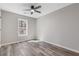 Bedroom with gray wood-look floors, ceiling fan, and window at 851 Ashley Ln, Stone Mountain, GA 30087