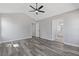 Large bedroom with gray wood-look floors, ceiling fan, and doorway to bathroom at 851 Ashley Ln, Stone Mountain, GA 30087