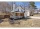 Side view of a two-story home with an attached garage, covered porch, and a partially fenced lawn at 851 Ashley Ln, Stone Mountain, GA 30087