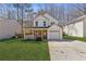 Charming two-story home with a front porch, attached garage, and well-manicured lawn at 851 Ashley Ln, Stone Mountain, GA 30087