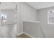Bright hallway with wood-look flooring, leading to a bedroom with fan and multiple windows at 851 Ashley Ln, Stone Mountain, GA 30087