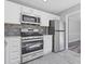 Kitchen featuring stainless steel appliances and white cabinets with view of dining area at 851 Ashley Ln, Stone Mountain, GA 30087