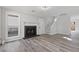 Open-concept living room featuring a dark fireplace, hardwood floors, and staircase access at 851 Ashley Ln, Stone Mountain, GA 30087