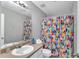 Well-lit bathroom featuring a vanity, toilet, and vibrant shower curtain at 1039 Bramble Way, Grayson, GA 30017