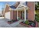 Close-up view of a home's brick front entrance with a decorated door and landscaped garden beds at 1039 Bramble Way, Grayson, GA 30017
