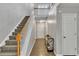 A bright hallway with a staircase, wood floors, and doors provides access to different parts of the home at 1039 Bramble Way, Grayson, GA 30017