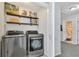 Well-organized laundry room with stainless steel washer and dryer and rustic shelves displaying decor and supplies at 1039 Bramble Way, Grayson, GA 30017