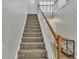 Carpeted staircase with a light wood handrail that leads to the upper level of the home at 1039 Bramble Way, Grayson, GA 30017