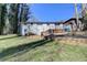 Large backyard with deck and retaining wall with a view of the home's back facade on a sunny day at 2945 Monterey Dr, Decatur, GA 30032