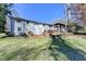 Large backyard with deck, stone wall and a view of the home's back facade on a sunny day at 2945 Monterey Dr, Decatur, GA 30032