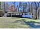 Charming one-story home with a manicured lawn, red front door, and attached carport at 2945 Monterey Dr, Decatur, GA 30032