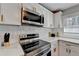 Close-up of range with stainless appliances, white cabinets and marble countertops at 2945 Monterey Dr, Decatur, GA 30032