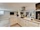 Contemporary kitchen boasts white cabinetry, stainless appliances, updated range hood and sleek countertops with gold hardware at 2945 Monterey Dr, Decatur, GA 30032
