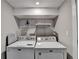 Spacious laundry room featuring two washing machines and shelving at 2945 Monterey Dr, Decatur, GA 30032