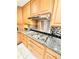 This kitchen has wood cabinets, granite countertops, stainless steel appliances, and a black and white tile backsplash at 4341 Kings Ne Way, Marietta, GA 30067