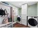 Functional laundry room with modern washer and dryer, storage cabinets, and a built-in bench for convenience at 1300 Valley Ct, Roswell, GA 30075