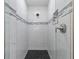 Close-up of glass-enclosed shower with gray and white tile at 1300 Valley Ct, Roswell, GA 30075