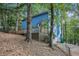 View of the blue home featuring a wooden deck and wooded surroundings at 1083 Lake Dr, Snellville, GA 30039