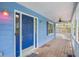 Inviting front porch with a blue door, vintage lighting, and a wood-planked floor at 1083 Lake Dr, Snellville, GA 30039