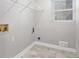 Laundry room with tile floors, a window, and hook ups for a washer and dryer at 1083 Lake Dr, Snellville, GA 30039