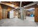 Spacious unfinished basement showcasing concrete flooring, exposed beams and HVAC, and a refrigerator at 160 Wing Mill Rd, Sandy Springs, GA 30350