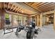 Unfinished basement area with natural light, exposed wood beams, and featuring a variety of exercise equipment at 160 Wing Mill Rd, Sandy Springs, GA 30350