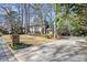 A brick house sits on a well-maintained lawn with a long driveway leading to a side-entry garage at 160 Wing Mill Rd, Sandy Springs, GA 30350