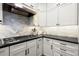 Modern kitchen featuring white cabinets, subway tile backsplash, and sleek black countertops at 160 Wing Mill Rd, Sandy Springs, GA 30350