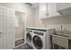 Convenient laundry room with modern washer and dryer, cabinets, and a utility sink at 160 Wing Mill Rd, Sandy Springs, GA 30350