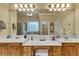 Bright bathroom featuring dual sinks, decorative mirrors, and a soaking tub at 1811 Mcconnell Rd, Grayson, GA 30017