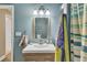 Bathroom featuring a wood look vanity with lighting, blue walls, and blue-striped shower curtain at 1811 Mcconnell Rd, Grayson, GA 30017