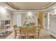 Open-concept dining room with light wood flooring, trey ceilings, a table, and wood chairs at 1811 Mcconnell Rd, Grayson, GA 30017