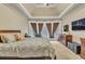 Comfortable main bedroom with tray ceiling, large windows, and carpet floors at 1811 Mcconnell Rd, Grayson, GA 30017