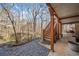 Cozy back porch with wooden stairs and a serene view of the wooded backyard and natural landscape at 217 Colonial Dr, Woodstock, GA 30189