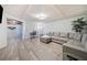 Finished basement area with grey sofa, office space, and an entrance to the unfinished section at 217 Colonial Dr, Woodstock, GA 30189