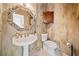Bathroom featuring an ornate mirror, pedestal sink, patterned wallpaper, and classic fixtures at 217 Colonial Dr, Woodstock, GA 30189