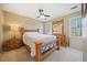 Cozy bedroom with natural light from the large window, ceiling fan, and wood furniture at 217 Colonial Dr, Woodstock, GA 30189