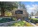 Stone community entrance sign surrounded by vibrant flowerbeds, creating a welcoming and upscale ambiance at 217 Colonial Dr, Woodstock, GA 30189