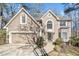 Charming home featuring a two-car garage, manicured lawn, and a welcoming front entrance and beige stucco at 217 Colonial Dr, Woodstock, GA 30189