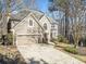 Charming home featuring a two-car garage, manicured lawn, and a welcoming front entrance and beige stucco at 217 Colonial Dr, Woodstock, GA 30189
