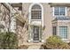 Elegant front entrance with decorative glass door, manicured bushes and plants, and beige stucco at 217 Colonial Dr, Woodstock, GA 30189