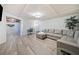 Finished basement featuring a sectional sofa and adjoining room with dart board at 217 Colonial Dr, Woodstock, GA 30189